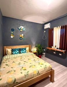 a bedroom with a bed and a blue wall at Shanti's Inn in General Luna