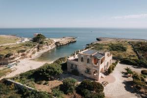an old house on a cliff next to the ocean at Villa Incina - Sea House in Polignano a Mare