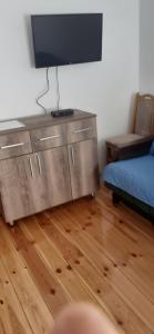 a living room with a flat screen tv on a dresser at Sušica Apartman in Kovačka Dolina