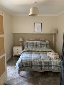 a bedroom with a bed with a blanket and a lamp at River View Cottage in Newton Stewart
