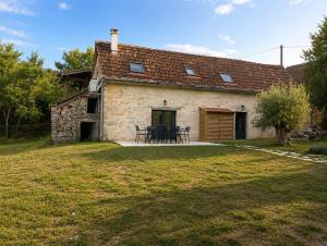 an old stone house with a table in front of it at Les maisons de Palis in Salvagnac-Cajarc