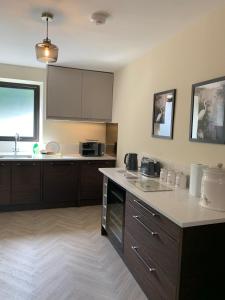 a kitchen with brown cabinets and a counter top at River View Cottage in Newton Stewart +38 photos