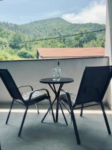 a table with two chairs and a bottle of wine on a balcony at SunnyOasis in Mostar
