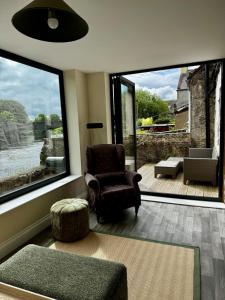a living room with a chair and a large window at River View Cottage in Newton Stewart