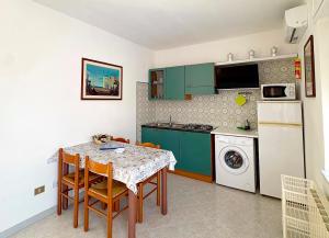a small kitchen with a table and chairs and a refrigerator at VILLA ROSSINI in Valledoria