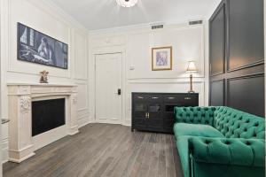 a living room with a green couch and a fireplace at Le Clos Saint-Louis - Par Aneyro in Quebec City