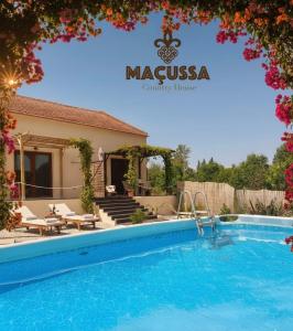 a villa with a swimming pool in a resort at Maçussa Country House in Massuça