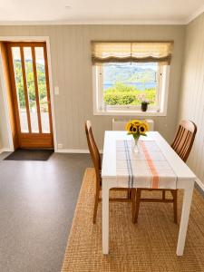 a white table with chairs and a vase of flowers on it at Jåsund SunView in Lyngdal