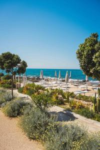 a beach with umbrellas and chairs and the ocean at Metamare in Cozze