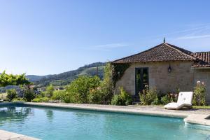 a villa with a swimming pool in front of a house at Casa do Capitan cdc in Leiro