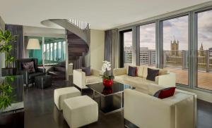 a living room with white furniture and large windows at Park Plaza London Westminster Bridge in London