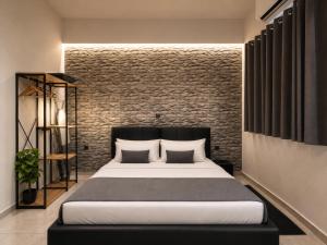 a bedroom with a bed and a brick wall at ILoveHome Mini in Kalamata