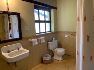 a bathroom with a sink and a toilet and a window at Hotel Museo Mayan Inn in Chichicastenango +31 photos