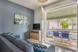 a living room with a couch and a table and chairs at Résidence Odalys Bleu Ocean in Moliets-et-Maa