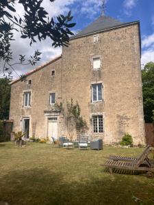 a large brick building with benches in a yard at Le pavillon des sœurs in Fontenille