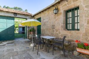 a table and chairs with a yellow umbrella on a patio at Casa do Capitan cdc in Leiro