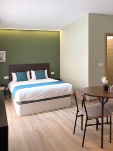 a bedroom with a bed and a table and a table and chair at Feliz Apartment in Madrid
