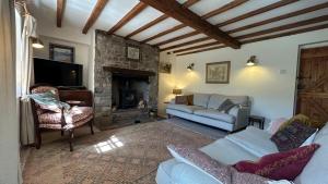 a living room with a couch and a fireplace at Tarn House in Hawes