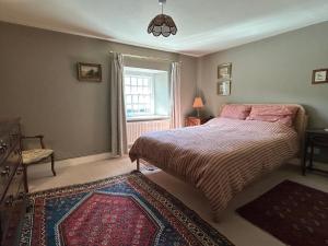 a bedroom with a bed with a rug and a window at Tarn House in Hawes