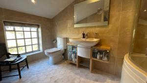a bathroom with a sink and a toilet and a tub at Tarn House in Hawes +28 photos