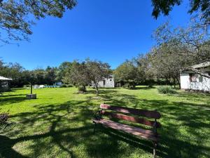 a park bench sitting in the middle of a field at El Paso Ibera Cabañas in Colonia Carlos Pellegrini