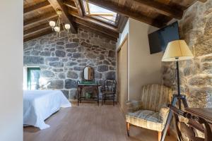 a bedroom with a bed and a stone wall at Casa do Capitan cdc in Leiro +41 photos