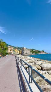 a beach with a fence next to the water at Hotel Fernanda in Rapallo
