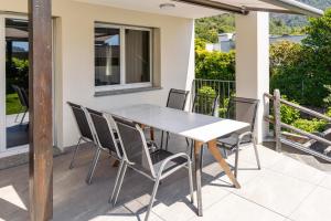 a dining table and chairs on a patio at Casa QUATTRO FIUMI in Tegna