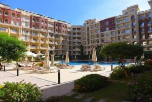 a large building with chairs and umbrellas in a courtyard at Florenza Khamsin Resort in Hurghada