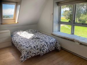 a small bedroom with a bed and a window at Main House - Rolsø Retreat in Knebel