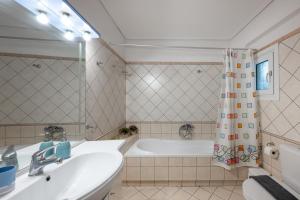 a bathroom with a tub and a sink at Makis Apartments in Tsoukalades +30 photos