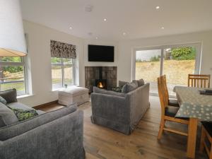 a living room with two couches and a fireplace at Brook Cottage in Coleraine