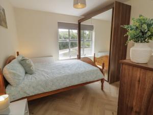 a bedroom with a bed and a large window at Brook Cottage in Coleraine