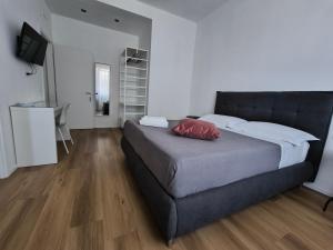 a bedroom with a bed with a red pillow on it at Faber Home in Conversano