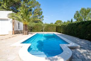 a swimming pool with a palm tree in a yard at Hauzify I Casa Cardona in Les tres Cales