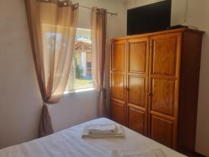 a bedroom with a bed and a dresser and a window at CCCA Monte Loureiro in Raposeira