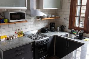 a kitchen with a stove and a sink at Planta Alta Bed & Breakfast in Buenos Aires +37 photos