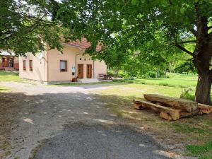 a tree with a log in front of a building at Apartmani Sorić in Prijeboj