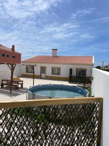 a house with a swimming pool in front of a fence at Lugar da Praia - Consolação - Peniche in Peniche