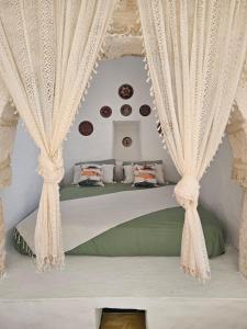 a bedroom with two beds with white curtains at Dar Chauphaly in Houmt Souk +45 photos
