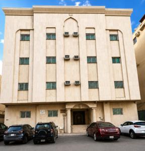 a building with cars parked in front of it at OrbitNet - Anwarat in Medina