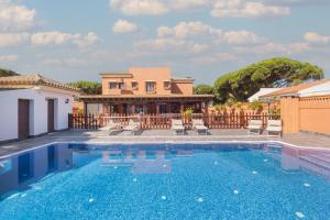 a villa with a swimming pool in front of a house at Hotel Amapola La Barrosa in Novo Sancti Petri