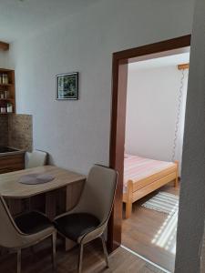 a room with a table and chairs and a bed at Apartmani Sorić in Prijeboj