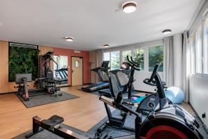 a gym with cardio machines and a man in the background at Residence du Parc - Val D'Europe in Montévrain