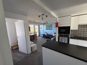 a kitchen and living room with white cabinets and a couch at 92 Blueberry Lodge - Sea Views in Westward Ho