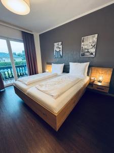 a bedroom with a large bed with a large window at Pension Hoogerland in Velden am Wörthersee +23 photos