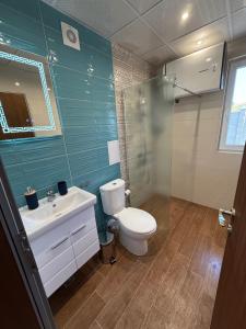 a bathroom with a toilet and a shower and a sink at Къща Грийн Хаус in Chernomorets