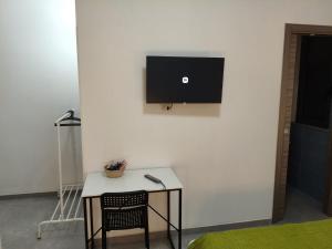 a table with a chair and a television on a wall at Affittacamere Domus Roseto in Roseto Capo Spulico +15 photos