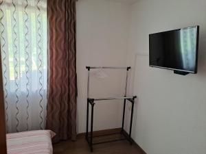 a flat screen tv hanging on a wall next to a window at Apartmani Sorić in Prijeboj