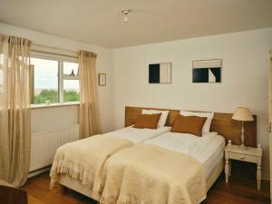 a bedroom with a large bed and a window at Kjarnholt in Kjarnholt